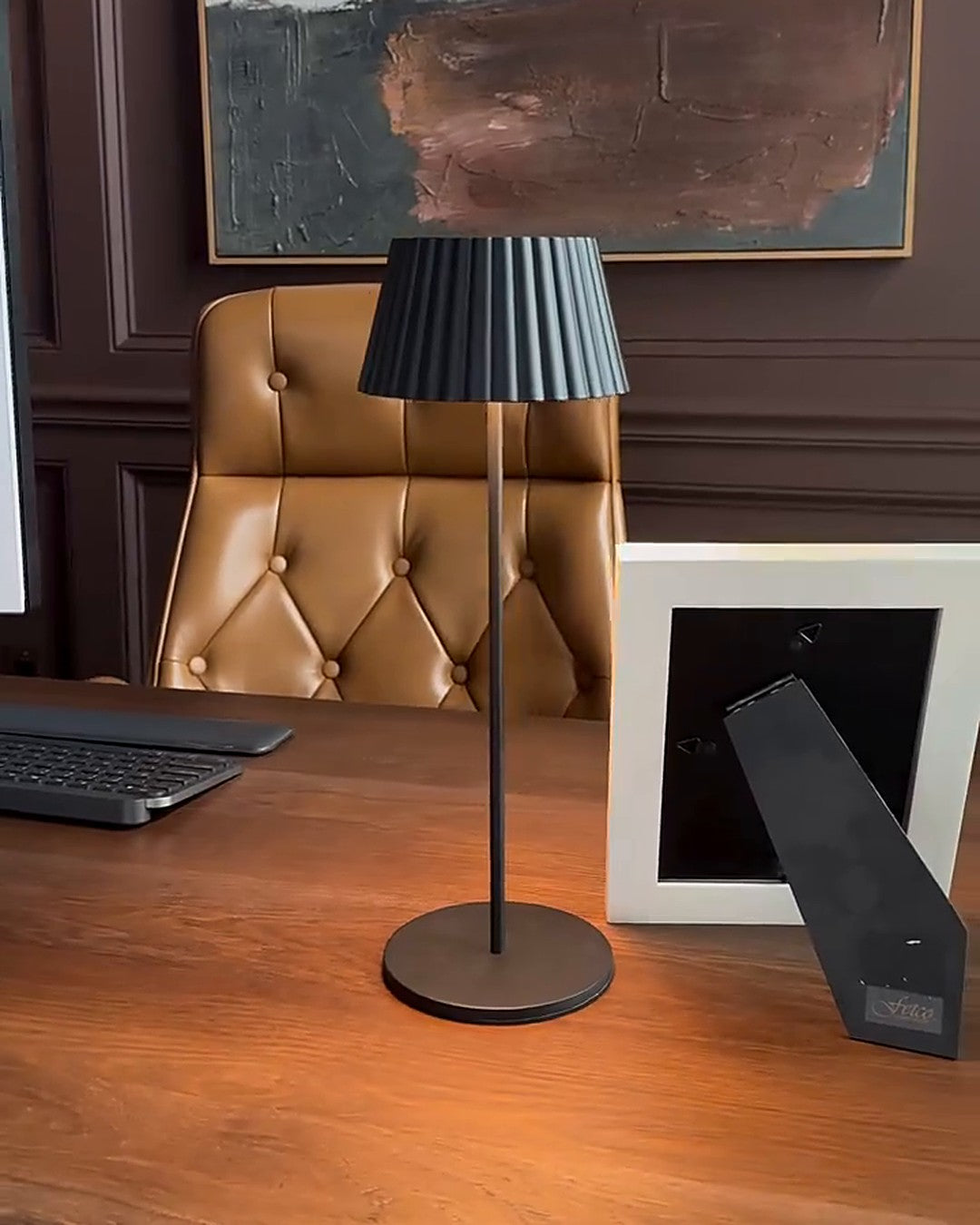 Aura cordless rechargeable table lamp glowing warm on a wooden desk