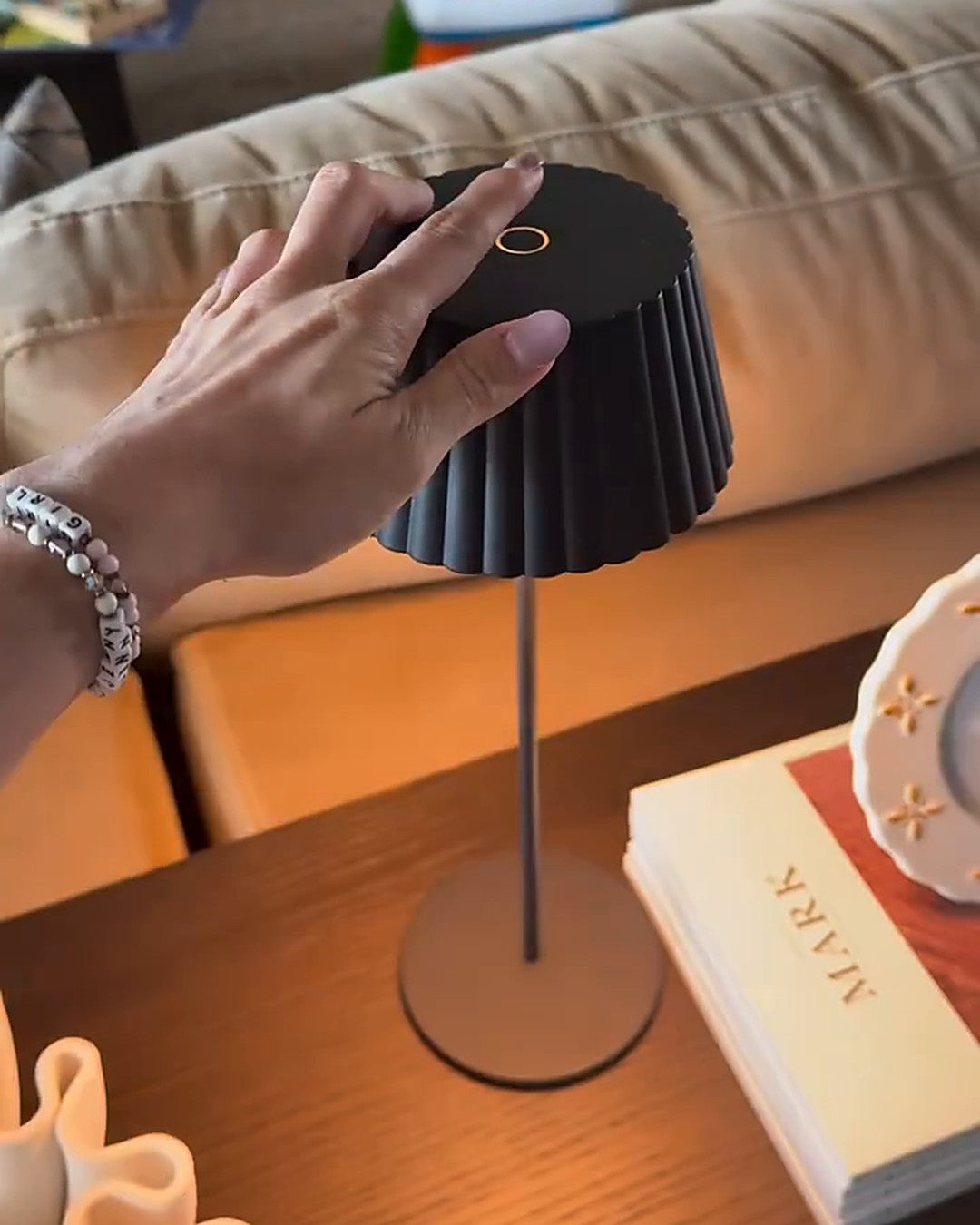 Touch control table lamp switched on with one tap on top of the shade
